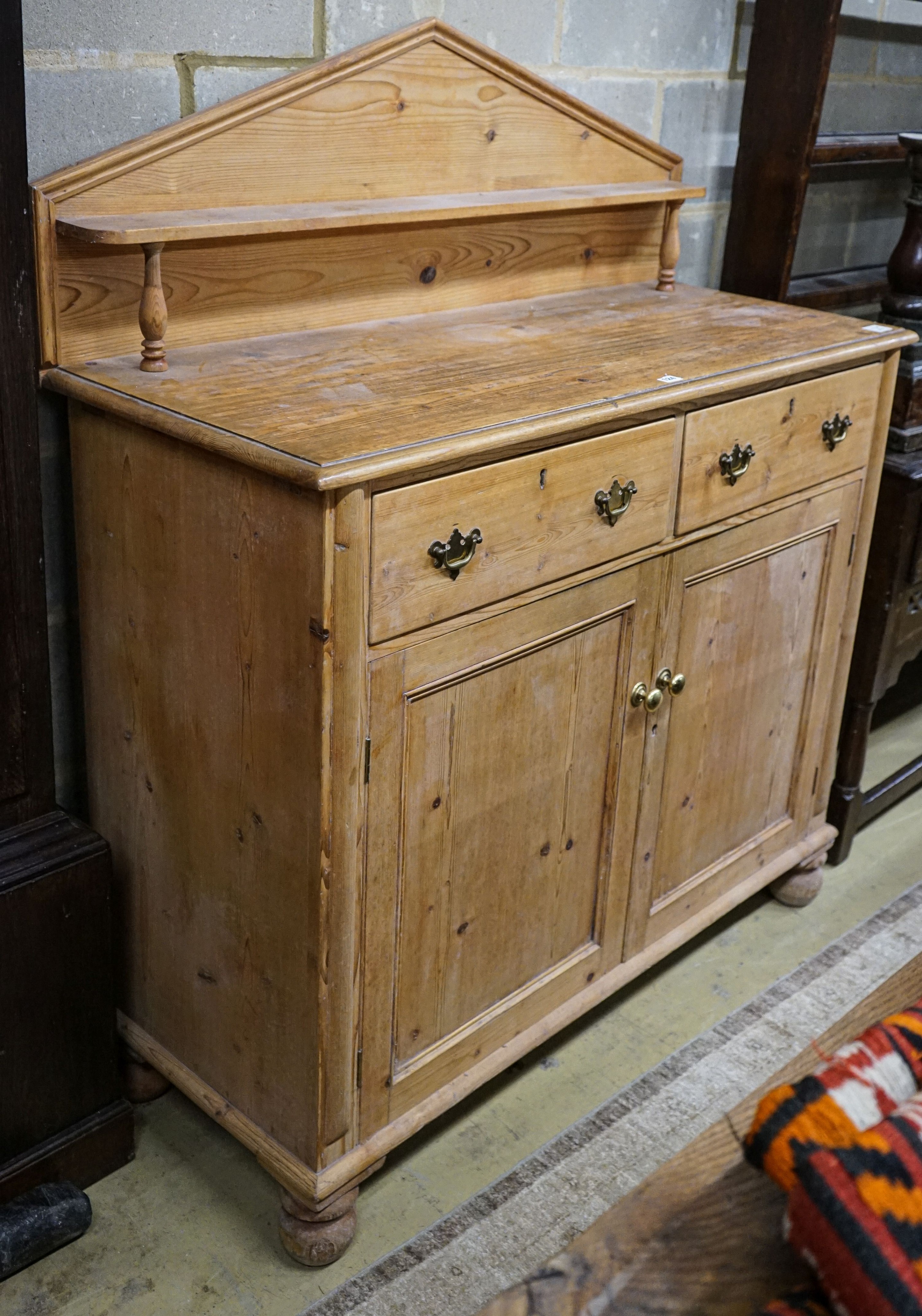 An early Victorian pine chiffonier, fitted two drawers and panelled doors on turned feet, width 121cm, depth 50cm, height 142cm